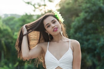 Photo of Woman in White Top Running Her Fingers Through Her Hair