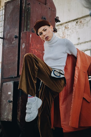 Photo of Woman in White Turtleneck Top Raising Her Left Leg in the Air
