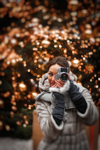 Photo of Woman in Winter Coat Taking a Photo
