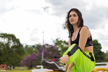 Photo of Woman in Workout Outfit Sitting On Steel Bar