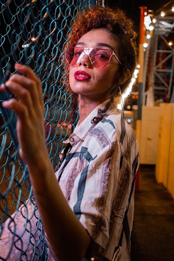 Photo of Woman Leaning Against Chain-link Fence