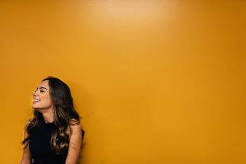 Photo of Woman Leaning Against Orange Wall
