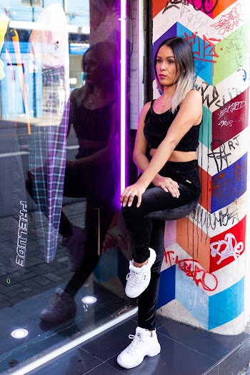 Photo of Woman Leaning Against Wall With Vandals