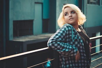 Photo of Woman Leaning Backwards on Metal Railing Looking up