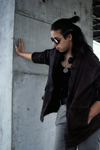 Photo of Woman Leaning Her Hand on Concrete Wall Posing While Looking Away