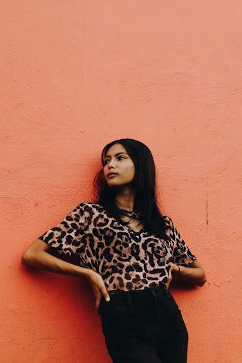 Photo of Woman Leaning Near Orange Wall