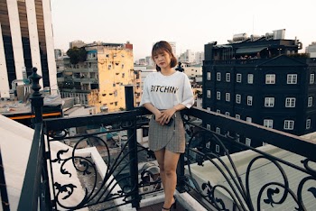 Photo of Woman Leaning on a Balcony's Black Metal Railing
