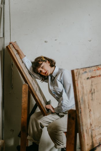 Photo of Woman Leaning on a Painting Easel