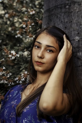 Photo of Woman Leaning on a Tree Trunk