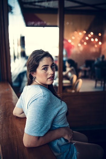 Photo Of Woman Leaning On A Wooden Table