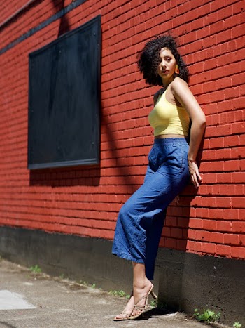 Photo of Woman Leaning on Brick Wall Posing