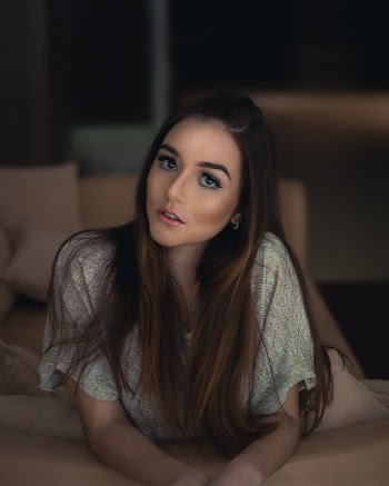 Photo of Woman Leaning on Brown Couch Back