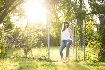 Photo of Woman Leaning on Cyclone Fence