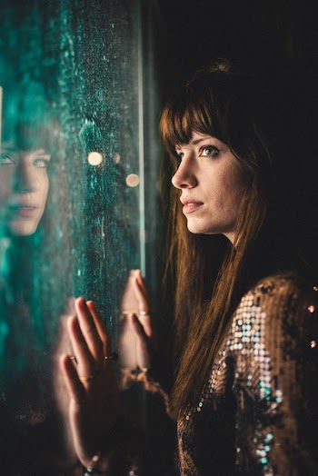 Photo of Woman Leaning On Glass Panel