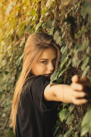 Photo of Woman Leaning on Grass Wall