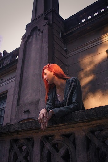 Photo of Woman Leaning on Gray Concrete Railing