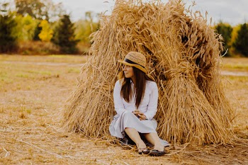 Photo of Woman Leaning on Haystack