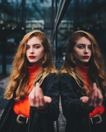 Photo of Woman Leaning on Mirrored Wall
