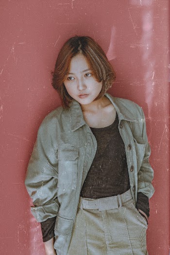 Photo Of Woman Leaning On Red Wall