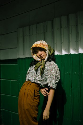 Photo of Woman Leaning on Steel Shutters