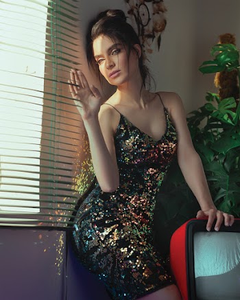 Photo of Woman Leaning on the Wall Beside Window