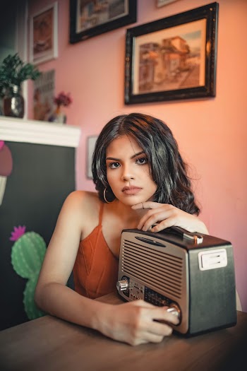 Photo of Woman Leaning On Vintage Radio