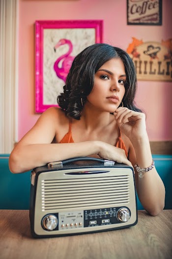 Photo of Woman Leaning On Vintage Radio