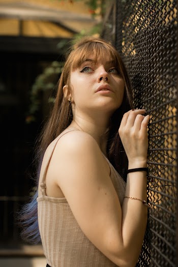 Photo of Woman Leaning on Wire Mesh