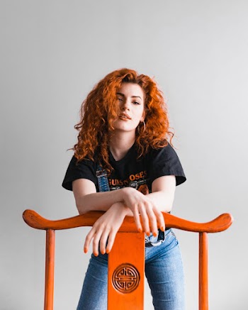 Photo of Woman Leaning on Wooden Chair