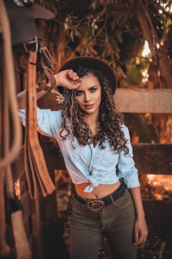 Photo of Woman Leaning on Wooden Fence