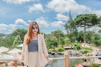 Photo of Woman Leaning on Wooden Railing
