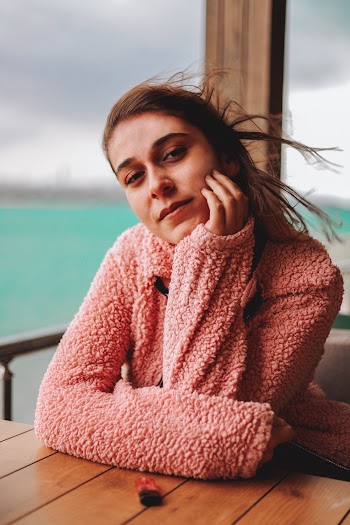 Photo of Woman Leaning on Wooden Table