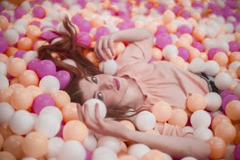 Photo of Woman Lying in Colorful Ball Pool 