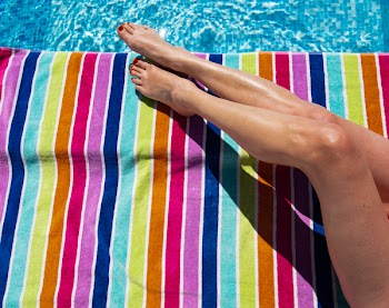 Photo of Woman Lying on Multicolored Towel
