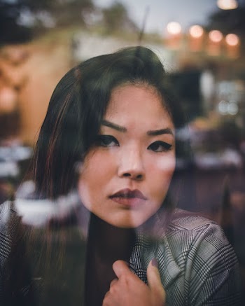 Photo Of Woman Near Glass Window