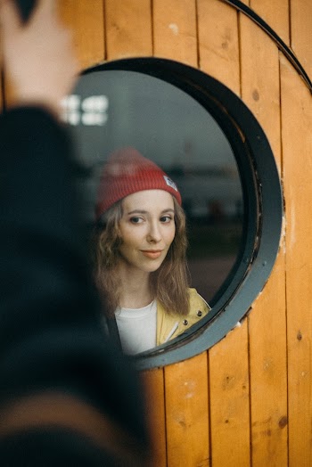 Photo of Woman Near Round Glass Window