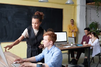 Photo Of Woman Pointing On Computer