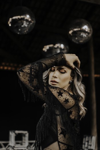 Photo of Woman Posing and While Wearing Black See Through Top