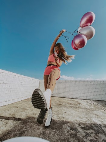Photo of Woman Posing While Holding Balloons