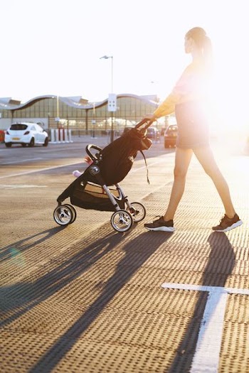 Photo of Woman Pushing a Stroller