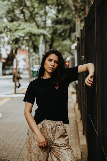 Photo of Woman Resting Arm on Black Metal Fence