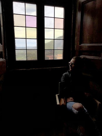 Photo of Woman Sitting Alone Near Window While Looking Outside