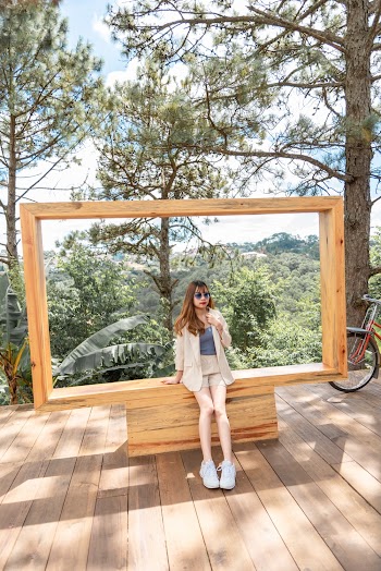Photo of Woman Sitting Alone on Brown Wooden Structure