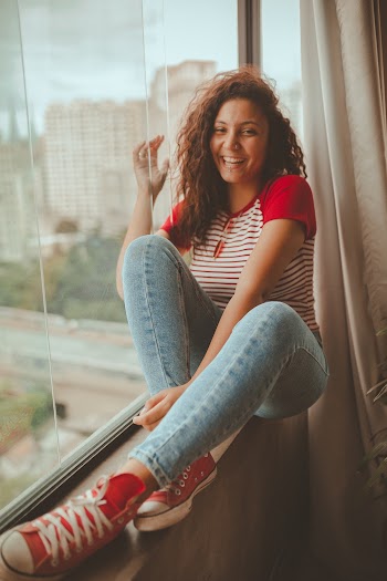 Photo Of Woman Sitting Beside The Window