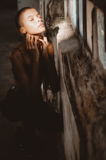 Photo Of Woman Sitting Beside Wall