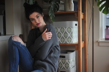Photo of Woman Sitting Beside Wooden Rack With Bins Posing