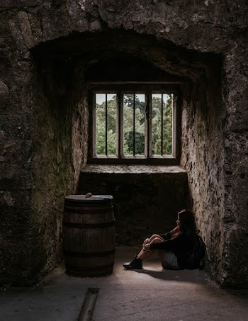 Photo Of Woman Sitting Down Next to Barrel