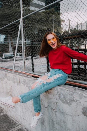 Photo Of Woman Sitting Near Chain Link Fence