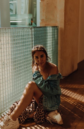 Photo Of Woman Sitting Near Glass Wall