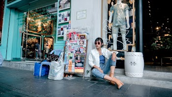 Photo Of Woman Sitting Near Magazines